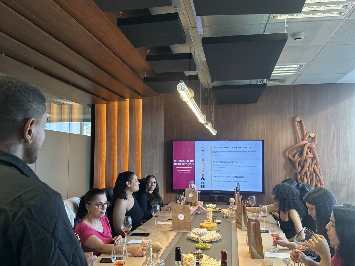Sommelier apresentando uma garrafa de vinho para um grupo sentado à mesa